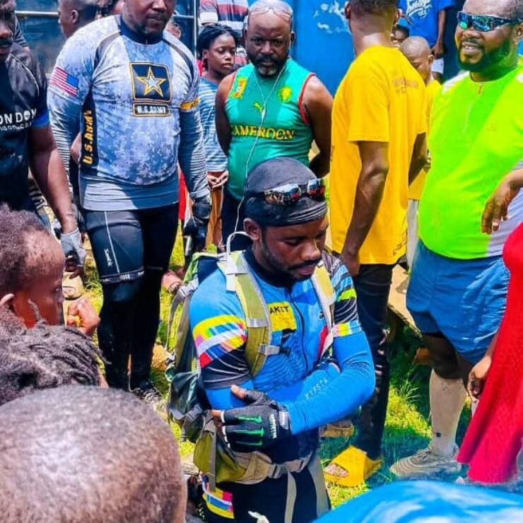 Emmiwuks standing with children benefiting from donations raised during his NIG2USA charity bicycle journey