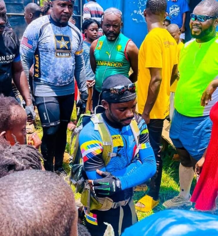 Emmiwuks standing with children benefiting from donations raised during his NIG2USA charity bicycle journey